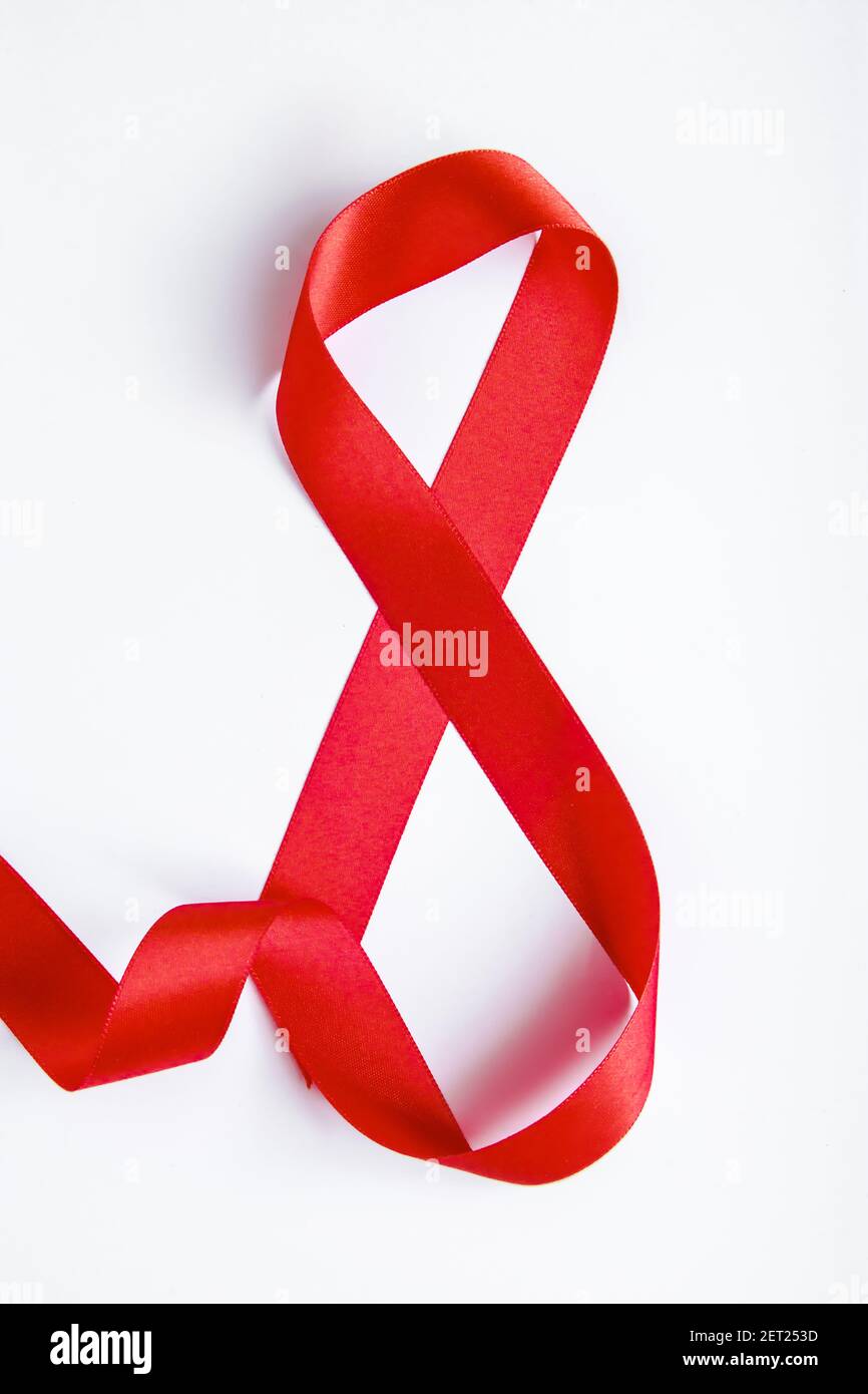 Nummer 8 aus rotem Seidenband auf weißem Hintergrund. Symbol für den internationalen Frauentag. Frühlingsferien am 8. März. Stockfoto