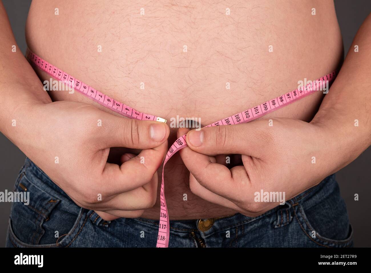 Fettleibigkeit ein Mann misst seinen großen Bauch mit einem Zentimeter, falsch Lifestyle Stockfoto