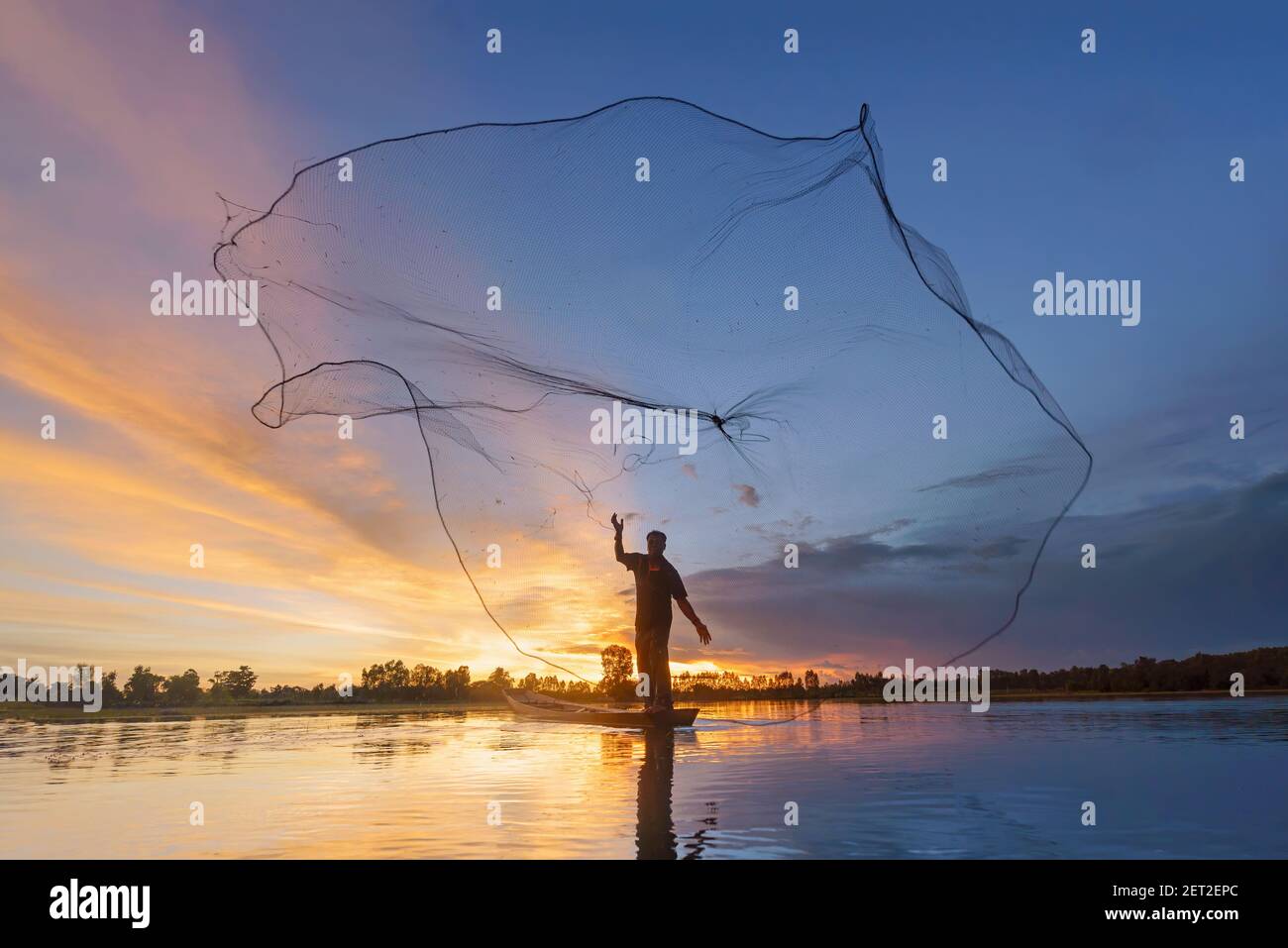 Silhouette eines Fischers, der ein Fischernetz in den Fluss wirft, Thailand Stockfoto