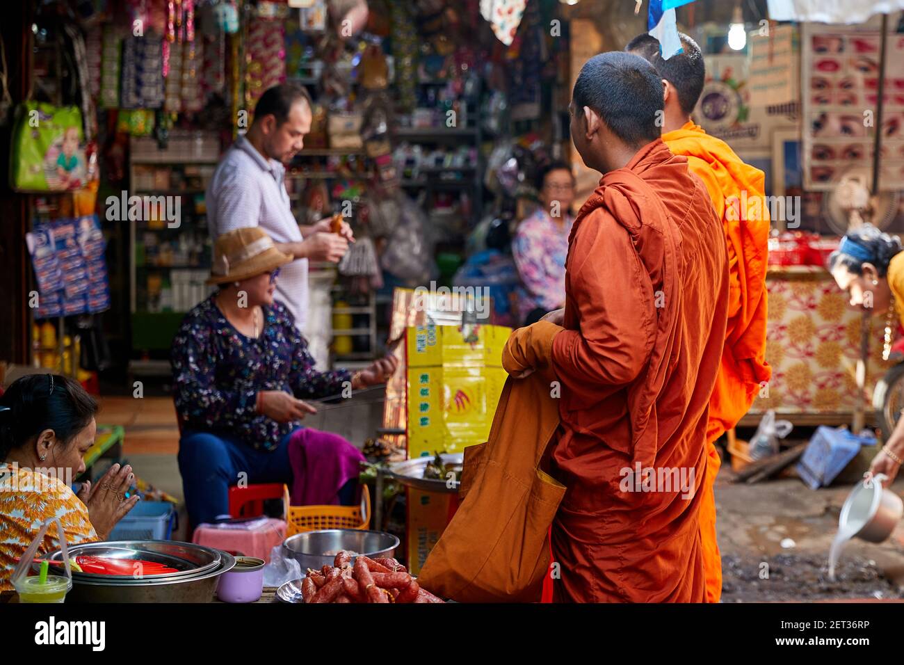 Buddhistischer Mönch sammelt Almosen auf einem feuchten Markt in Phnom Penh, Kambodscha Stockfoto