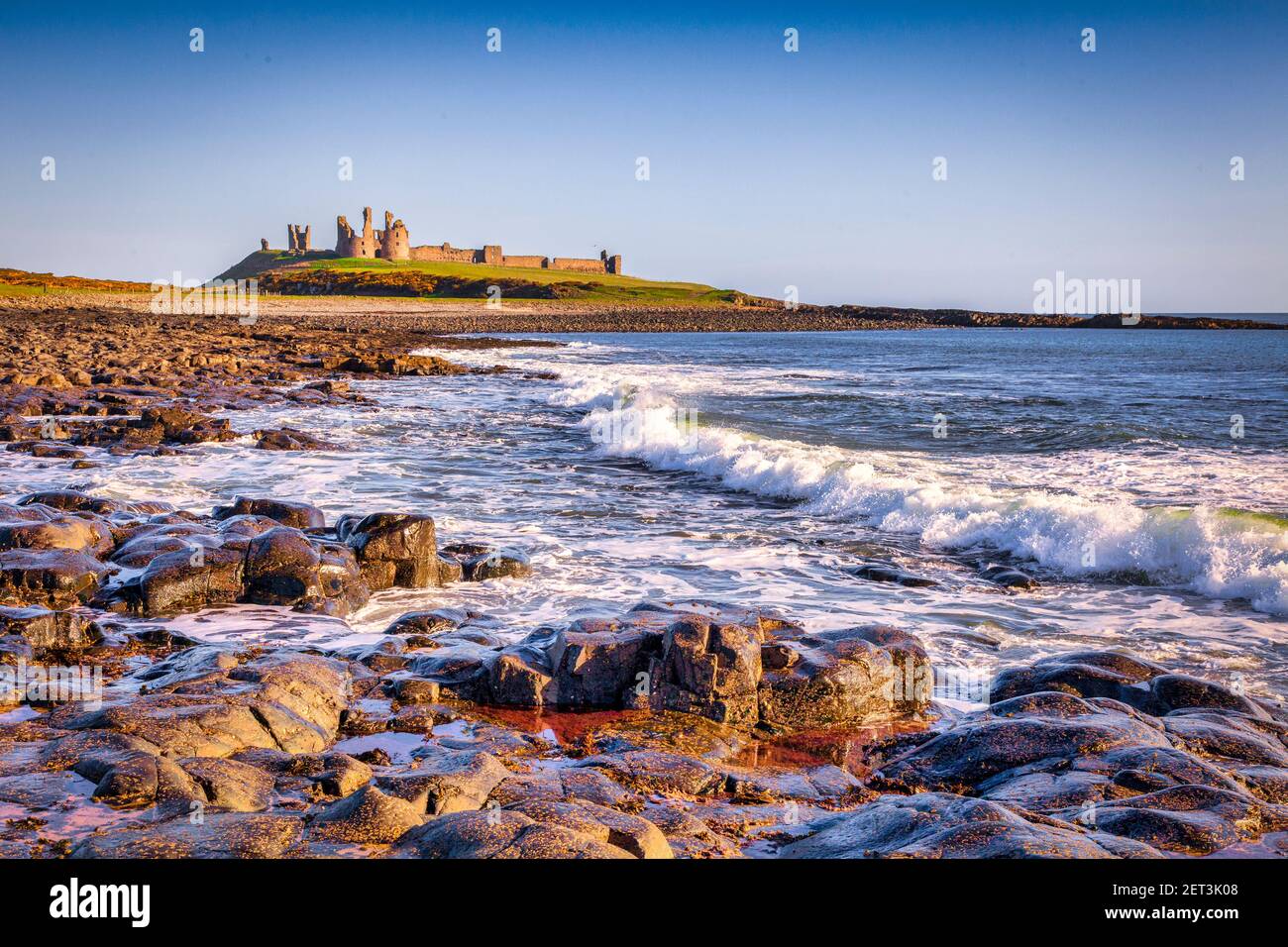 Dunstanburgh Castle an der Northumberland Küste an einem klaren Frühlingsmorgen. Stockfoto