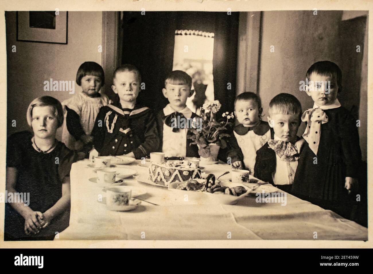 Deutschland - UM 1920s: Gruppenfoto von sieben kleinen Mädchen und Jungen auf Kindergeburtstag. Vintage Archiv Art Deco Ära Fotografie Stockfoto