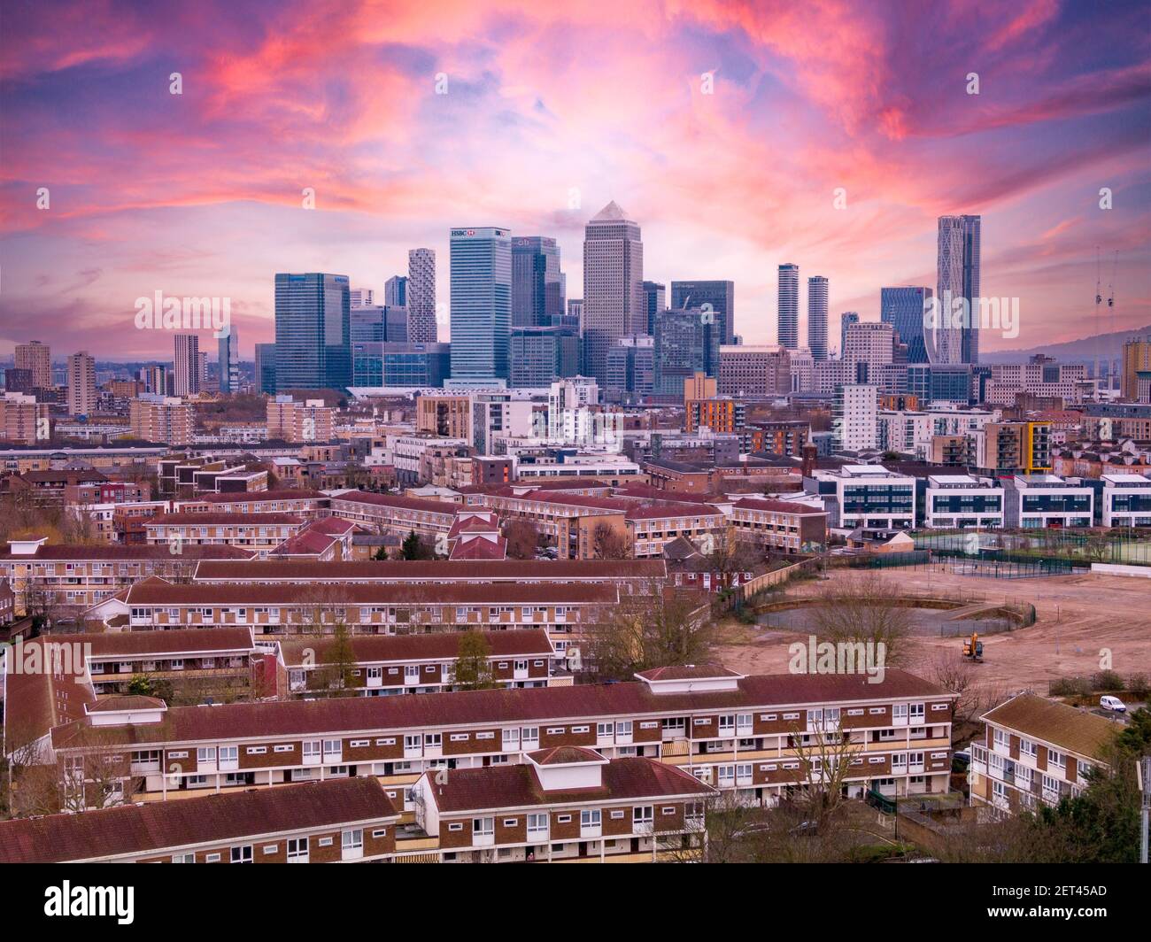 Skyline von London mit Canary Wharf in der Ferne und der Kontrast der flachen Wohnhäuser im Vordergrund Stockfoto