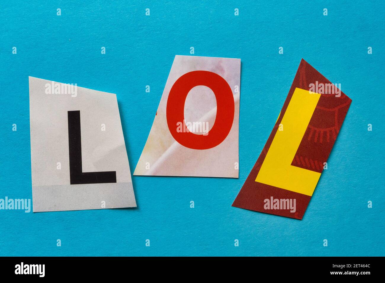 Das Akronym „LOL“ (Laugh Out Loud) mit ausgeschnittenen Papierbuchstaben in der Lösegeld-Note-Effekt-Typografie, USA Stockfoto