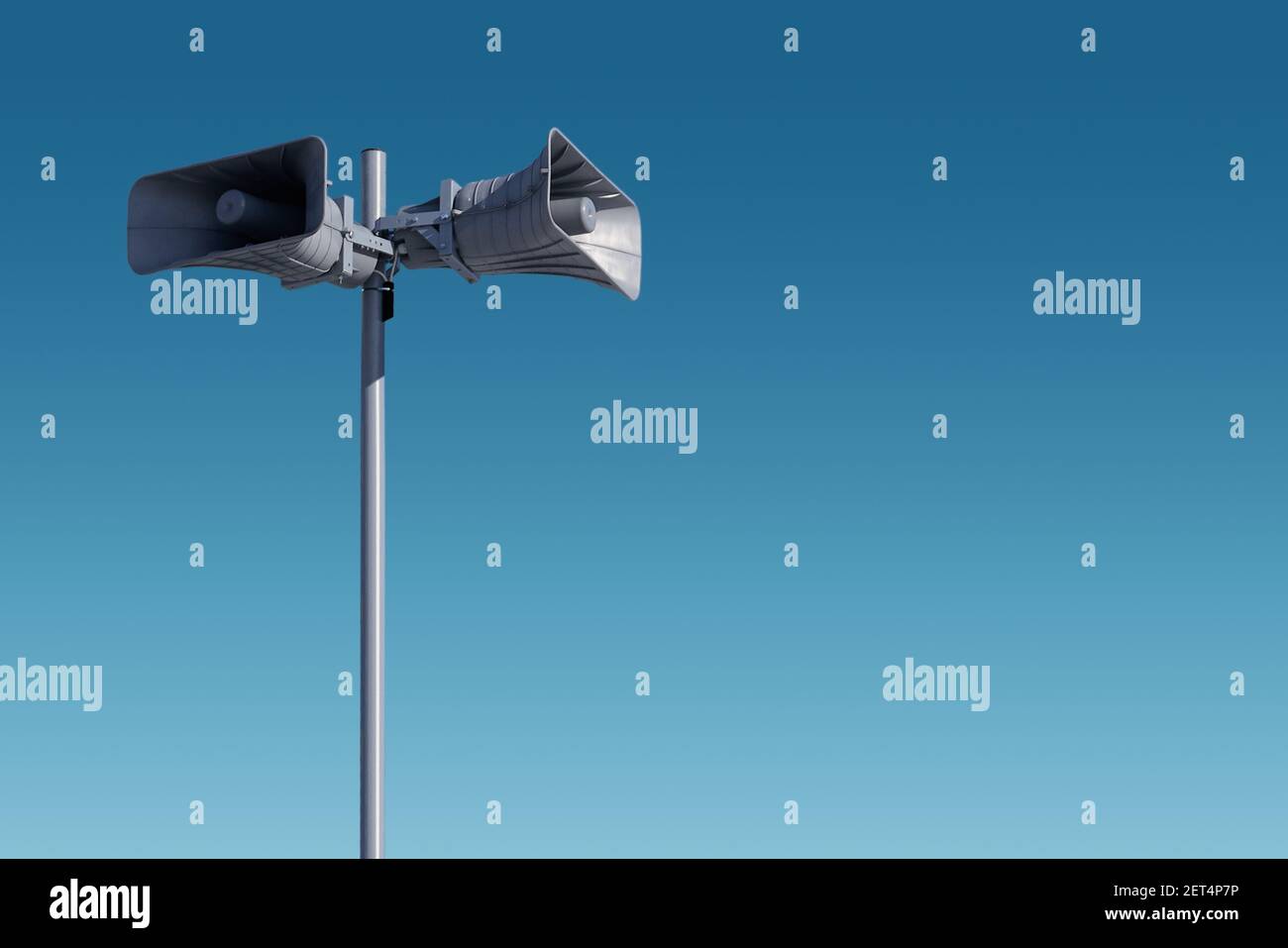 Eine hohe Säule mit zwei grauen Lautsprechern gegen den Himmel. Das System der allgemeinen Warnung der Bevölkerung vor der Gefahr. Möglichkeit, Ihren Test zu veröffentlichen Stockfoto