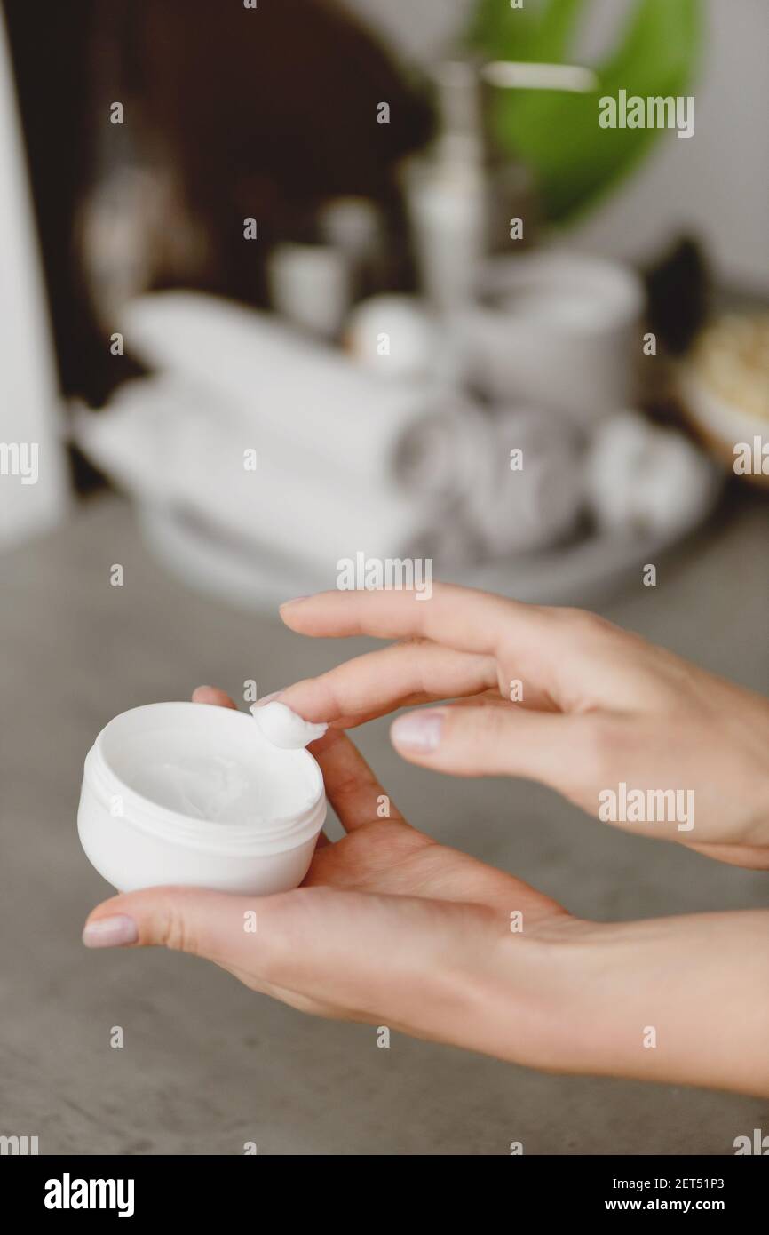 Nahaufnahme der Frau Hände halten Behälter mit Hautpflegecreme in den Händen. Stockfoto