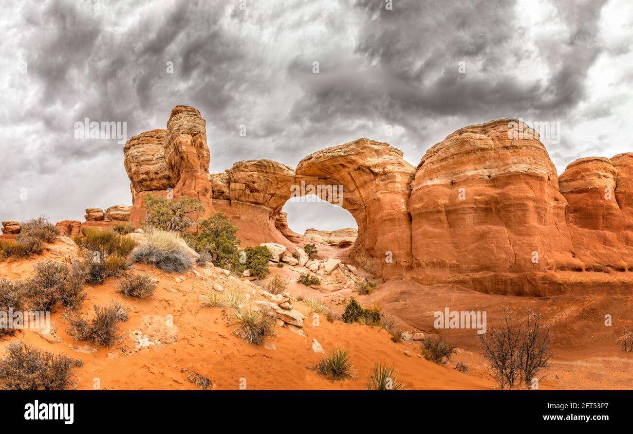 Der berühmte Broken Arch im Arches National Park, Utah und dramatische dunkle Wolken Stockfoto