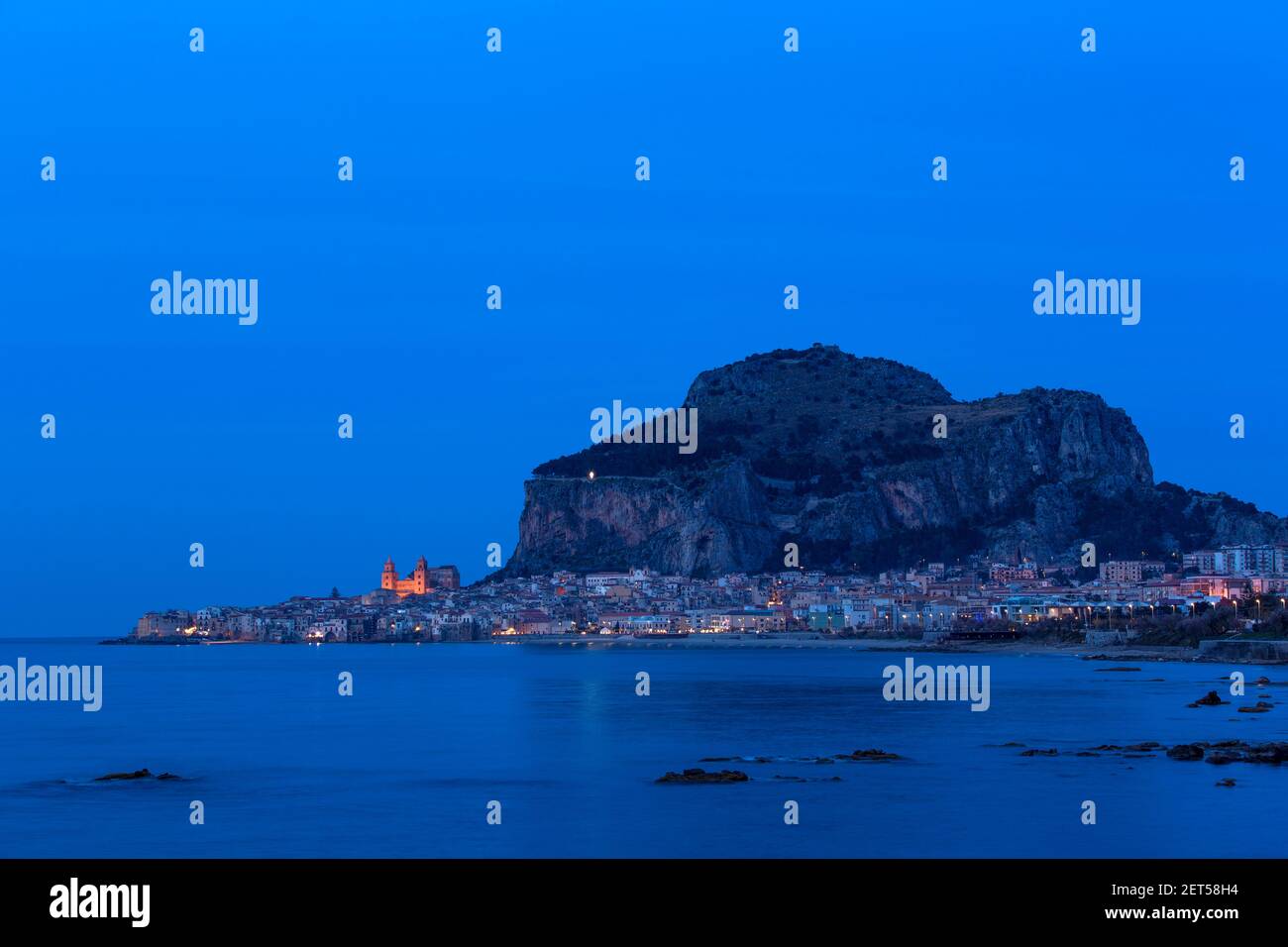 Italien, Sizilien, Cefalu, ein Blick auf das Meer der Stadt beleuchtet am Abend mit der Rocca eine normannische mittelalterliche Festung Stockfoto