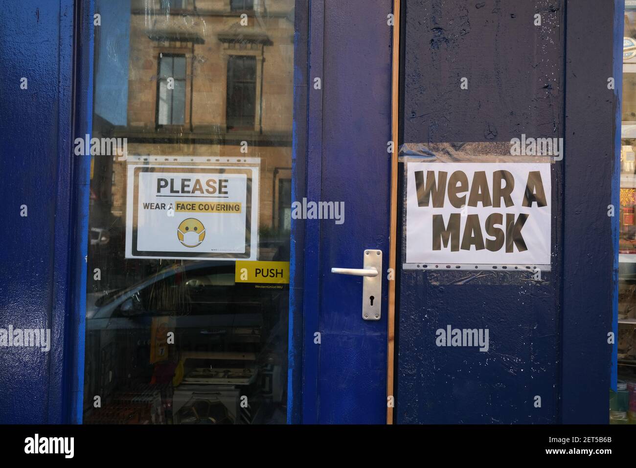 Glasgow, Großbritannien, am 1. März 2021. Schilder an den Fenstern der Geschäfte und der Geschäfte, die die Leute anweisen, die Sicherheitsprotokolle beizubehalten und Masken zu tragen. Mehr als 1,5 Millionen Menschen haben jetzt ihre erste Covid-19-Coronavirus-Impfung in Schottland erhalten. Foto: Jeremy Sutton-Hibbert/Alamy Live News. Stockfoto