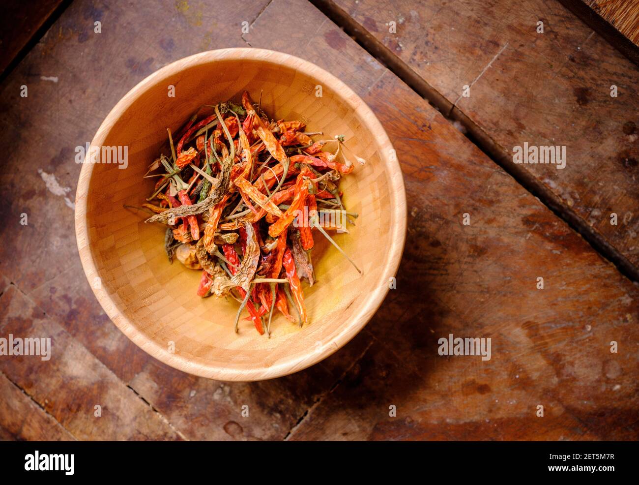 Getrocknete Chilis in einer rustikalen Holzschüssel von oben. Stockfoto