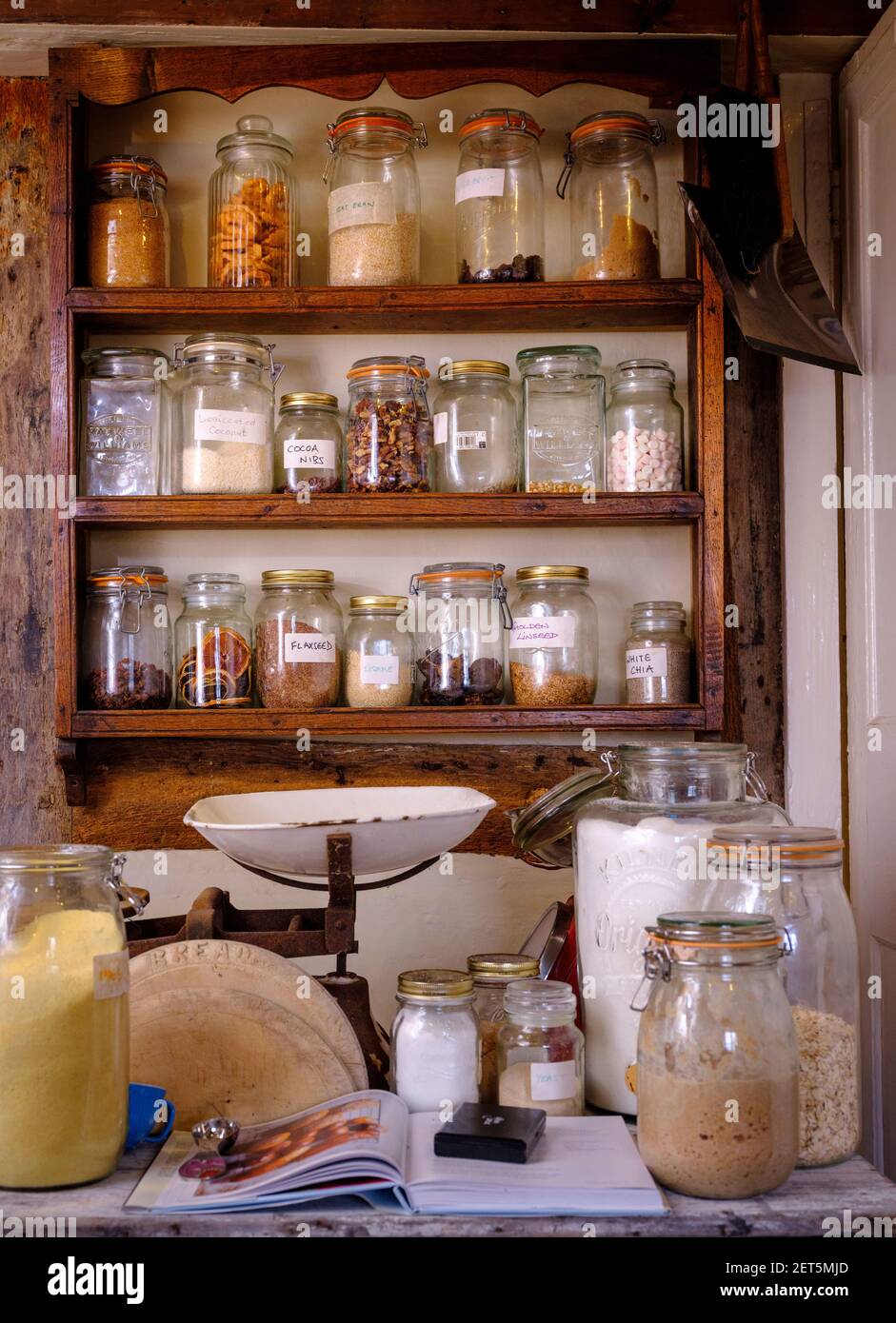 Gläser mit Zutaten auf Regalen in einer rustikalen Küche, Großbritannien Stockfoto