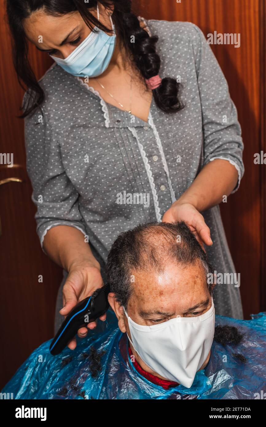 Tochter schneidet ihrem Vater die Haare zu Hause Stockfoto