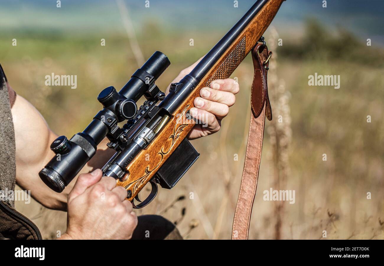 Jäger. Jagdzeit. Mann mit Gewehr, Gewehr. Der Mensch lädt ein Jagdgewehr. Prozess der Jagd während der Jagdsaison. Männliche Jäger in bereit zu Stockfoto