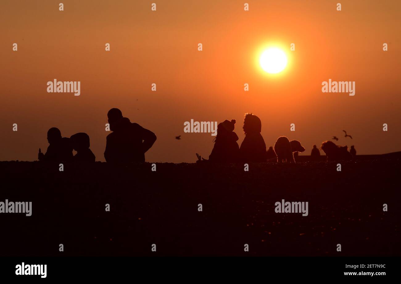 Brighton UK 1st March 2021 - am ersten Tag des meteorologischen Frühlings in Großbritannien versammeln sich die Massen an der Strandpromenade von Brighton am Pier, um das tägliche sternenhafte Murmeln bei Sonnenuntergang zu beobachten : Credit Simon Dack / Alamy Live News Stockfoto