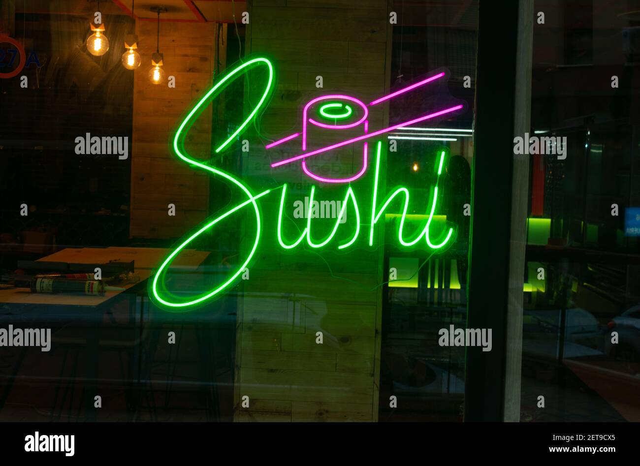 Eine Nahaufnahme eines leuchtenden Neonlichts Schild von A Sushi-Bar an einer Glaswand Stockfoto