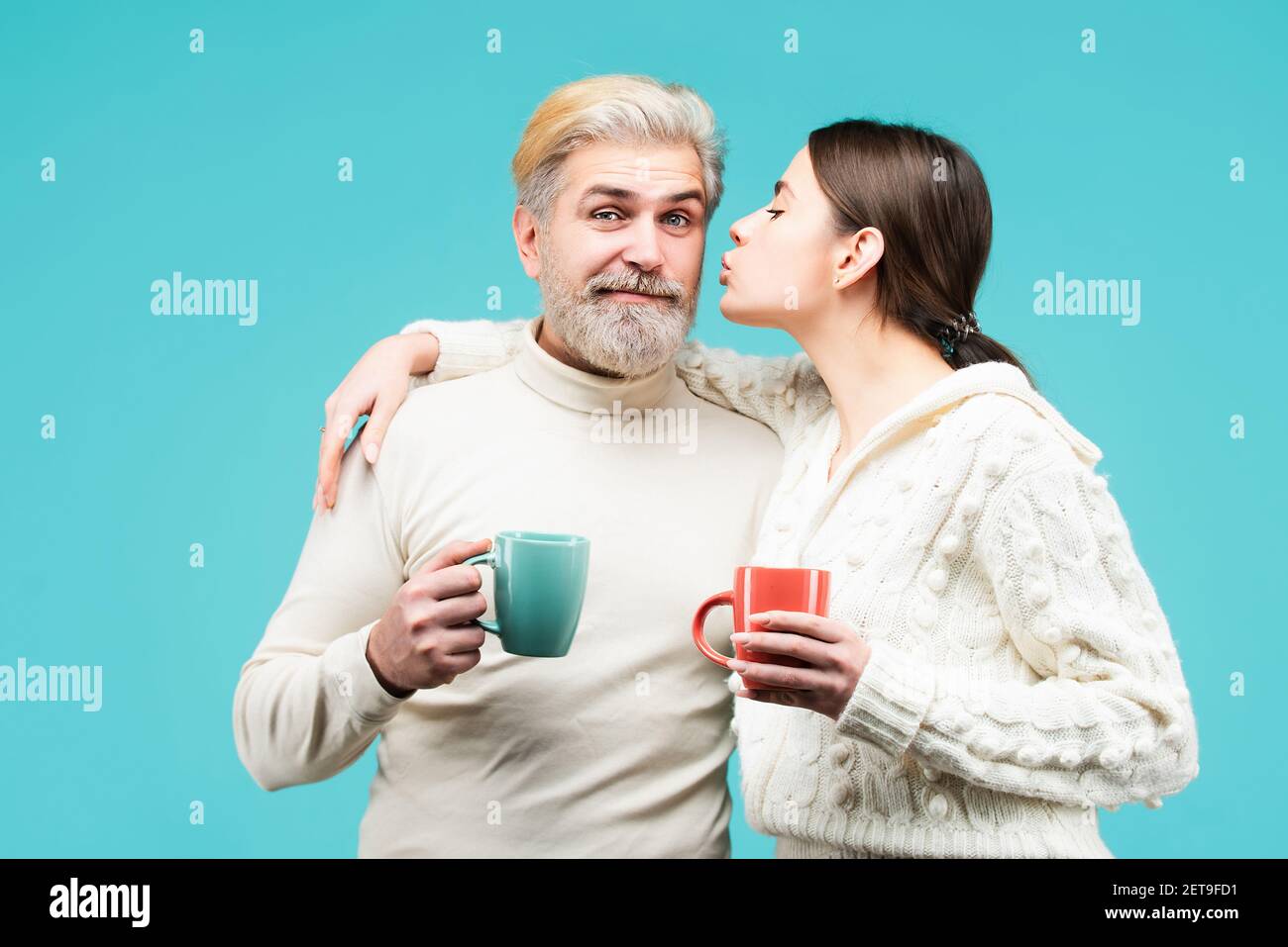 Ein glückliches Paar am Morgen mit einer Tasse Kaffee oder Tee. Genießen Sie schöne Familie gemütlichen Abend zusammen. Junges Paar mit einem romantischen Momente. Stockfoto