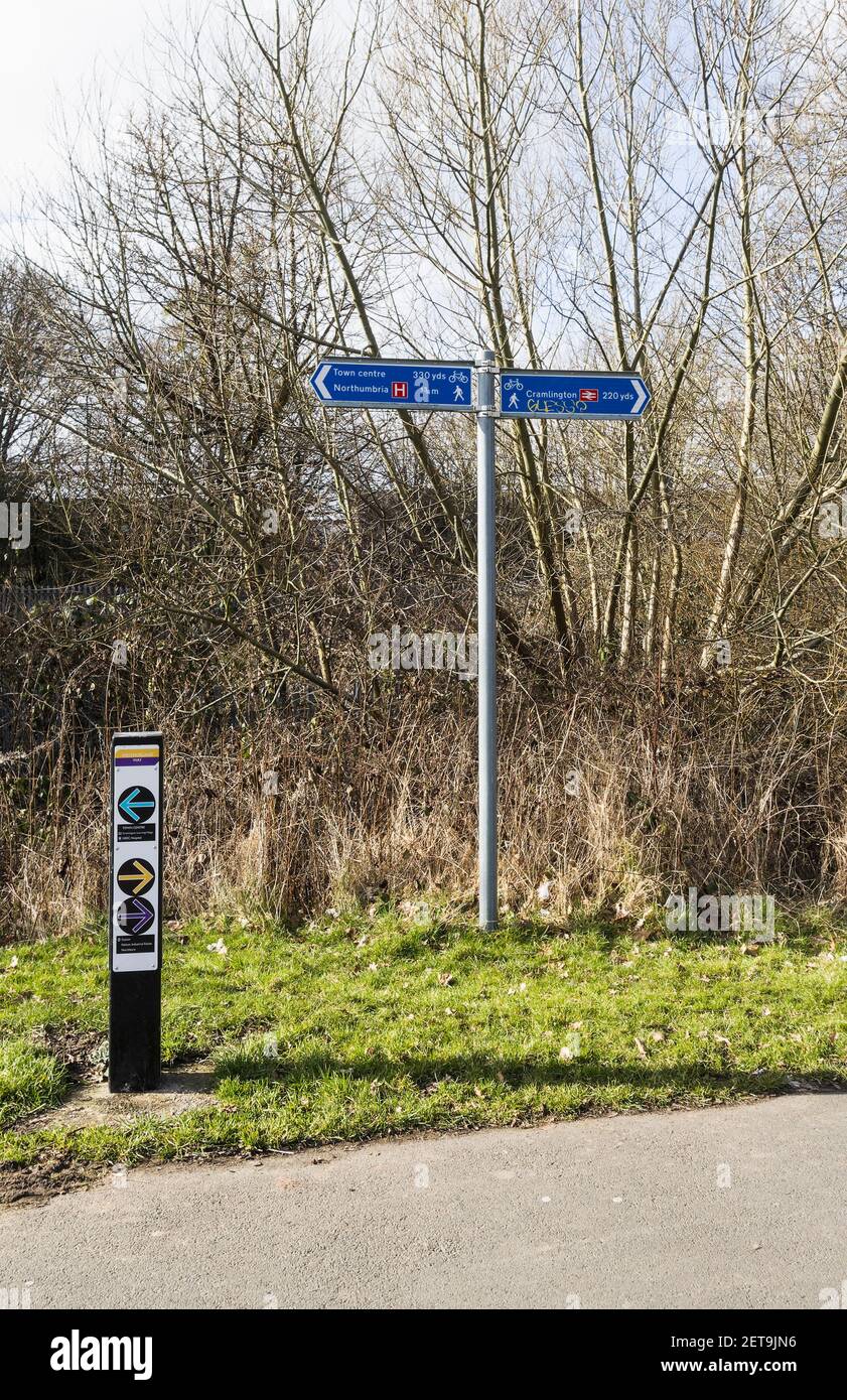Richtungsschilder zu Sehenswürdigkeiten wie Krankenhaus und Bahnhof, die auch Wander- und Radwege zeigen. Stockfoto