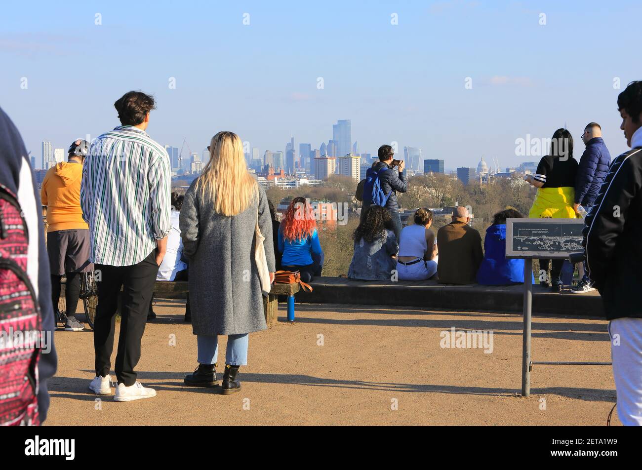 Menschen, die die Aussicht auf die Stadt in der Wintersonne auf Primrose Hill, im Norden von London, Großbritannien, betrachten Stockfoto