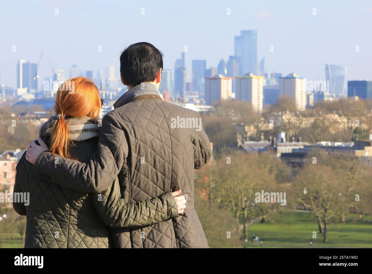 Menschen, die die Aussicht auf die Stadt in der Wintersonne auf Primrose Hill, im Norden von London, Großbritannien, betrachten Stockfoto