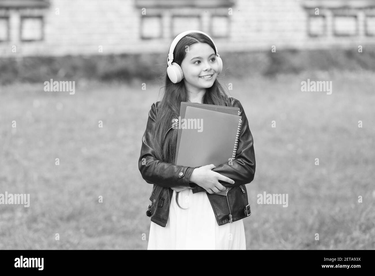 Schulmädchen hören Hörbücher auf dem Weg zur Schule, studieren mit Vergnügen Konzept. Stockfoto
