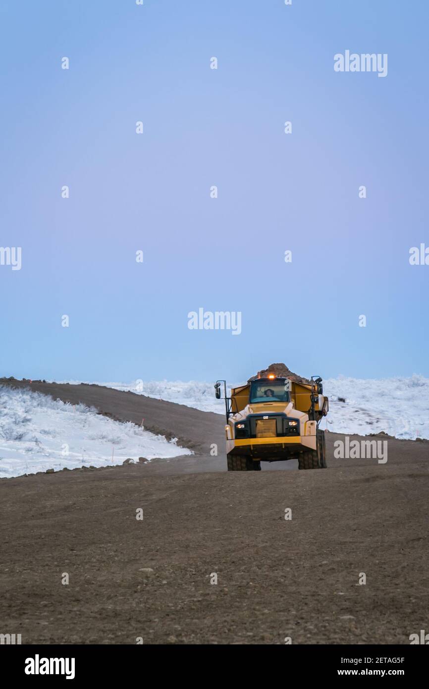 LKW schleppt Kies entlang der Inuvik-Tuktoyaktuk Highway während der Winterbauarbeiten, Northwest Territories, Kanadas Arktis. Stockfoto