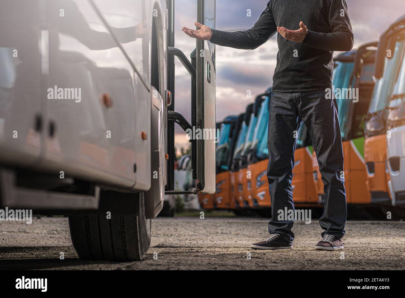Kaukasischer Busfahrer in seiner 40s Begrüßung Passagiere während des Aufenthalts und Begrüßung neben Tour Bus Tür. Thema Automobil und Transport. Stockfoto
