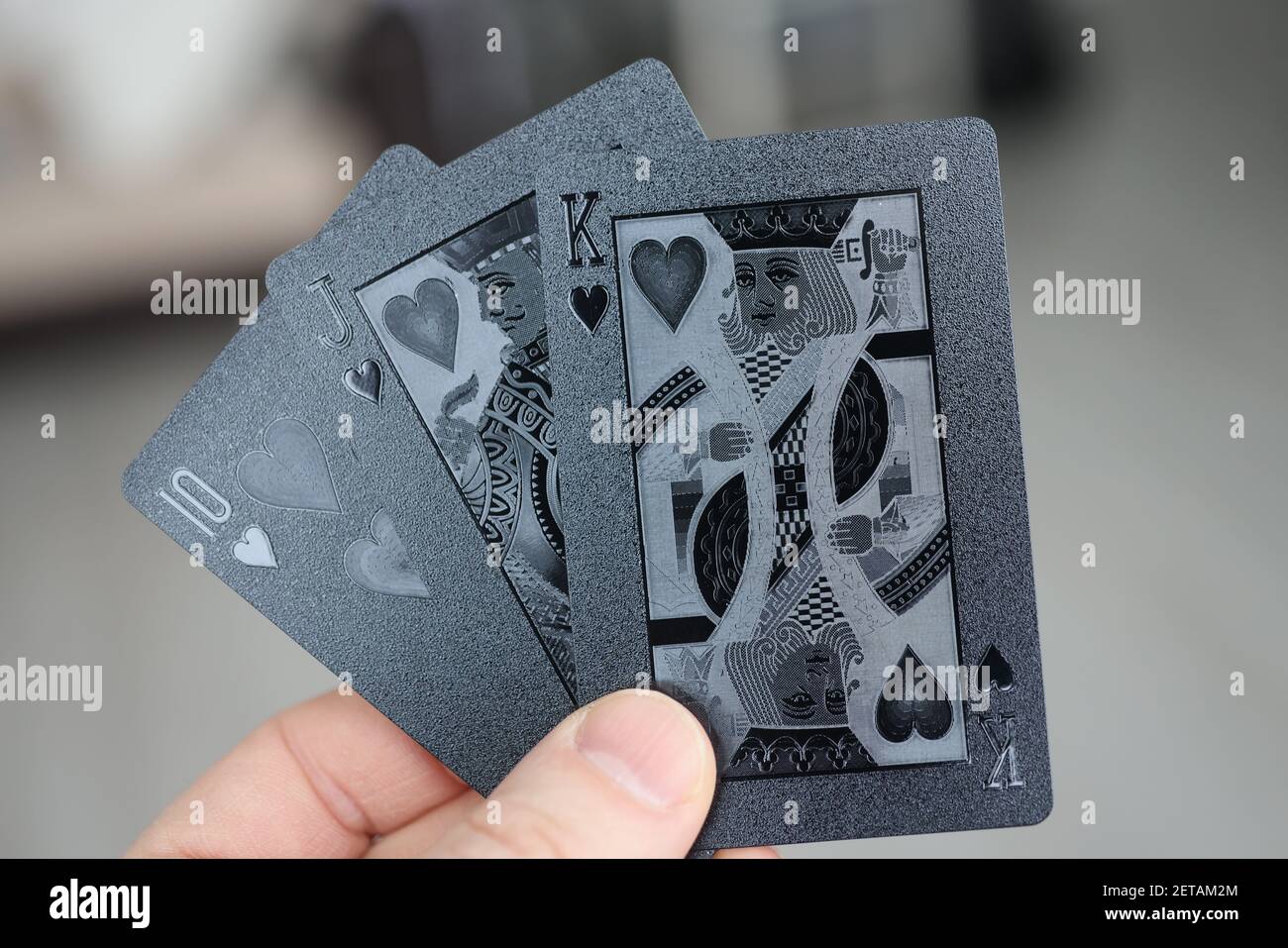 Männliche Hand hält schwarze Spielkarten Nahaufnahme Stockfoto