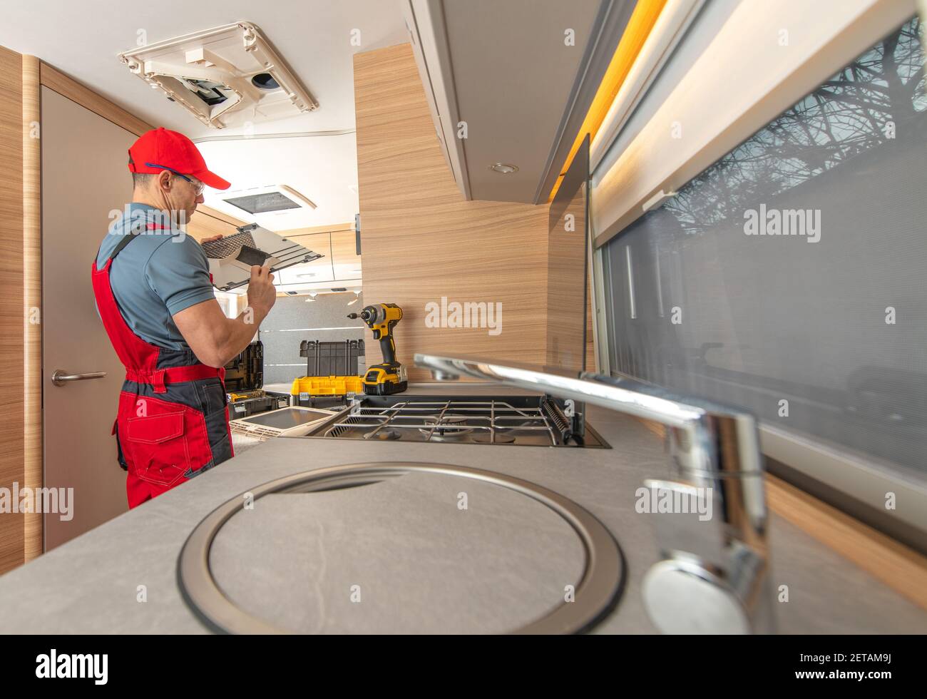 Freizeitfahrzeug RV Wohnmobil Geräte Kaukasischen Techniker in seinem 40s Reparatur-Klimaanlage Einheit im modernen Reise-Anhänger. Stockfoto