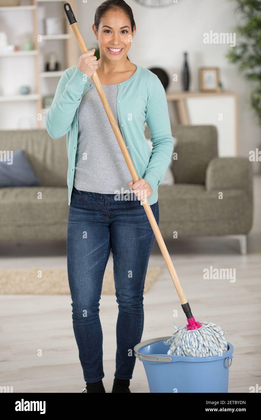 Glückliche Frau mit Mopp Reinigung Boden und singen zu Hause Stockfoto
