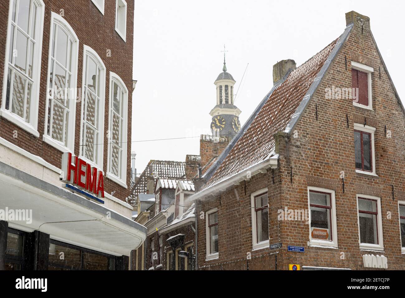 ZUTPHEN, NIEDERLANDE - 08. Feb 2021: Außenfassade von modernen und historischen mittelalterlichen Gebäuden im Handelszentrum der Hansestadt mit einem Zeichen der t Stockfoto