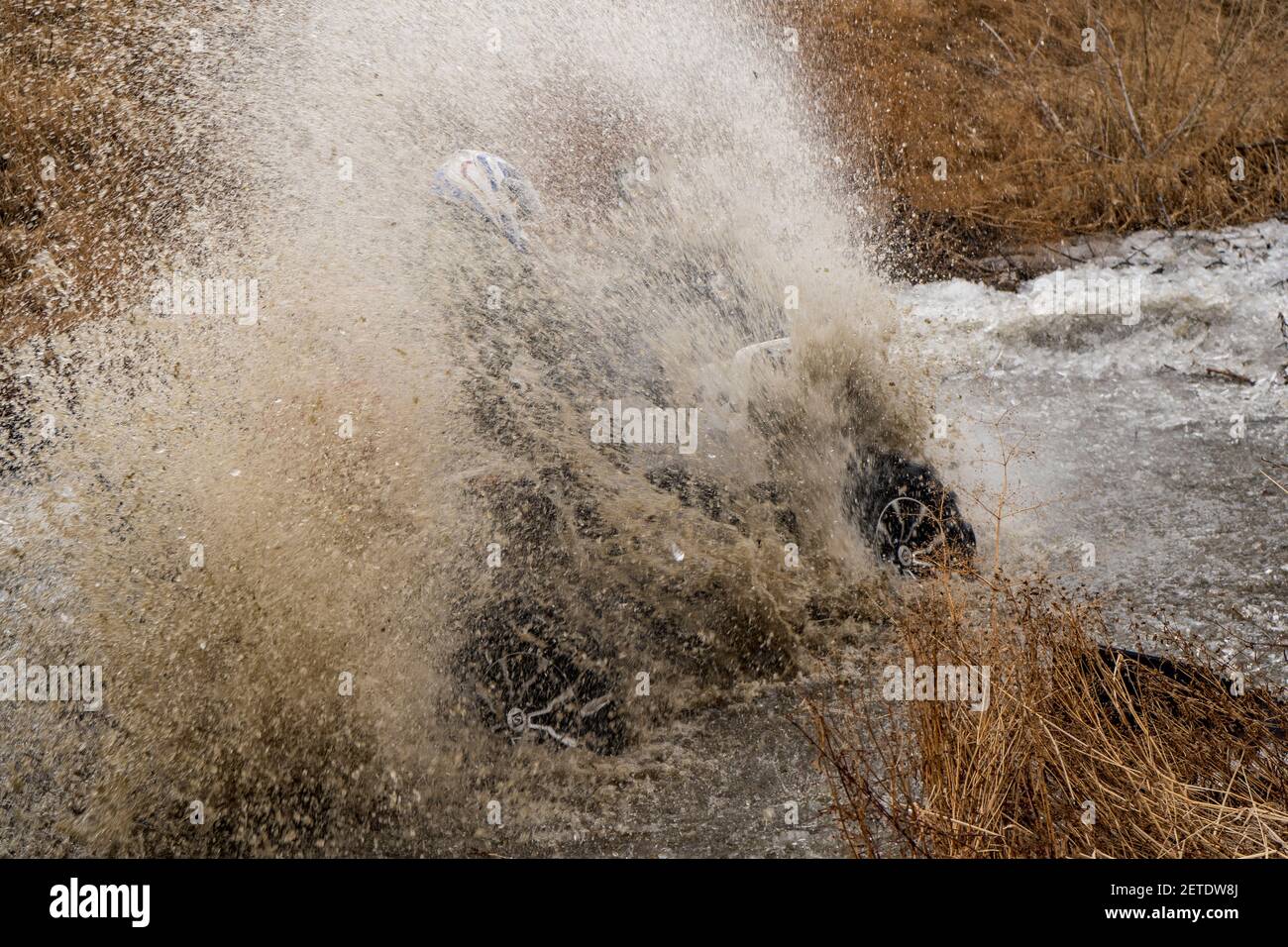 Der Mann auf dem ATV kreuzt einen Stream. Touristischen Spaziergänge auf einem cross-country Gelände. Stockfoto