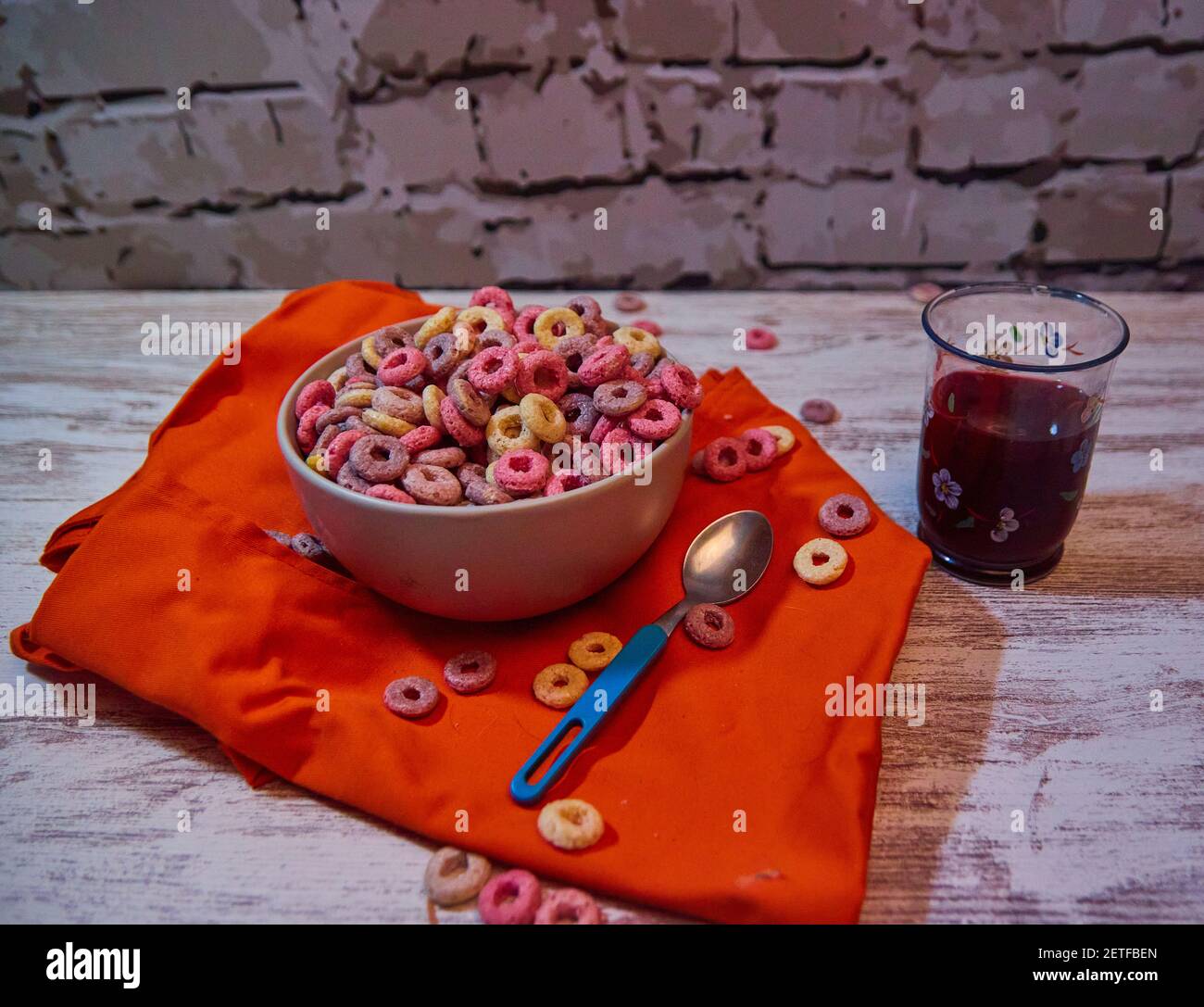 Bunte Cerealien voller Zucker mit rotem Fruchtsaft Stockfoto