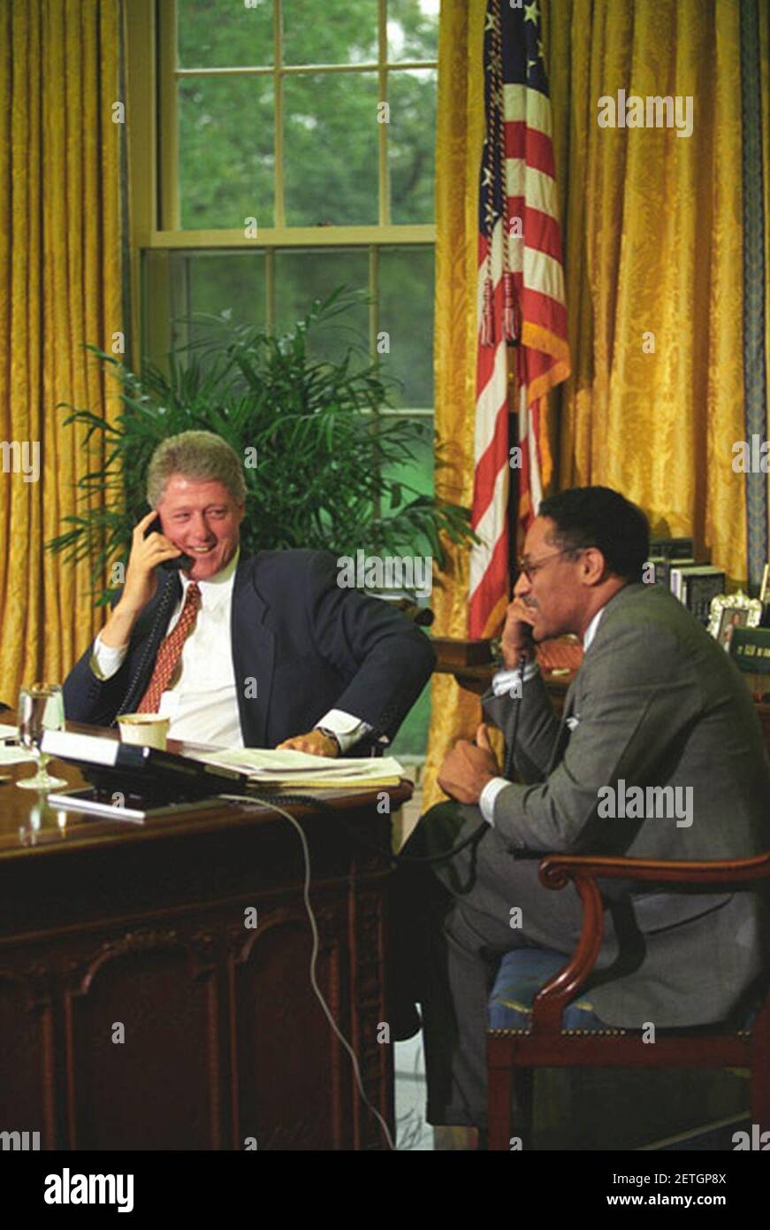 Foto von Präsident William J. Clinton und Landwirtschaftsminister Mike Espy am Telefon im Oval Office. Stockfoto