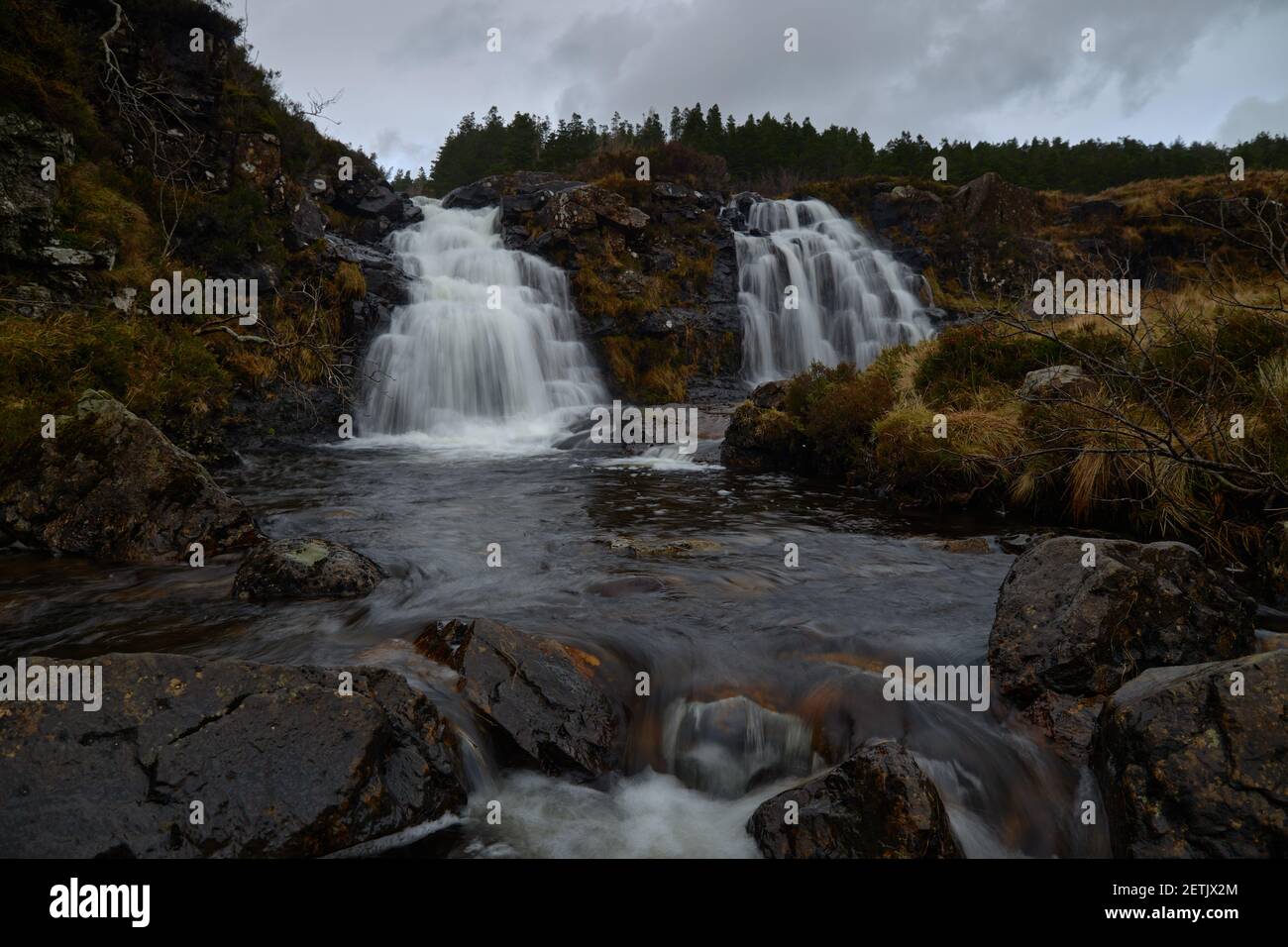 Doppelter Wasserfall im Fluss mit seidigem Wasser. Trockenes Herbstgras - Fairy Pools - Skye Island - Schottland - UK Stockfoto