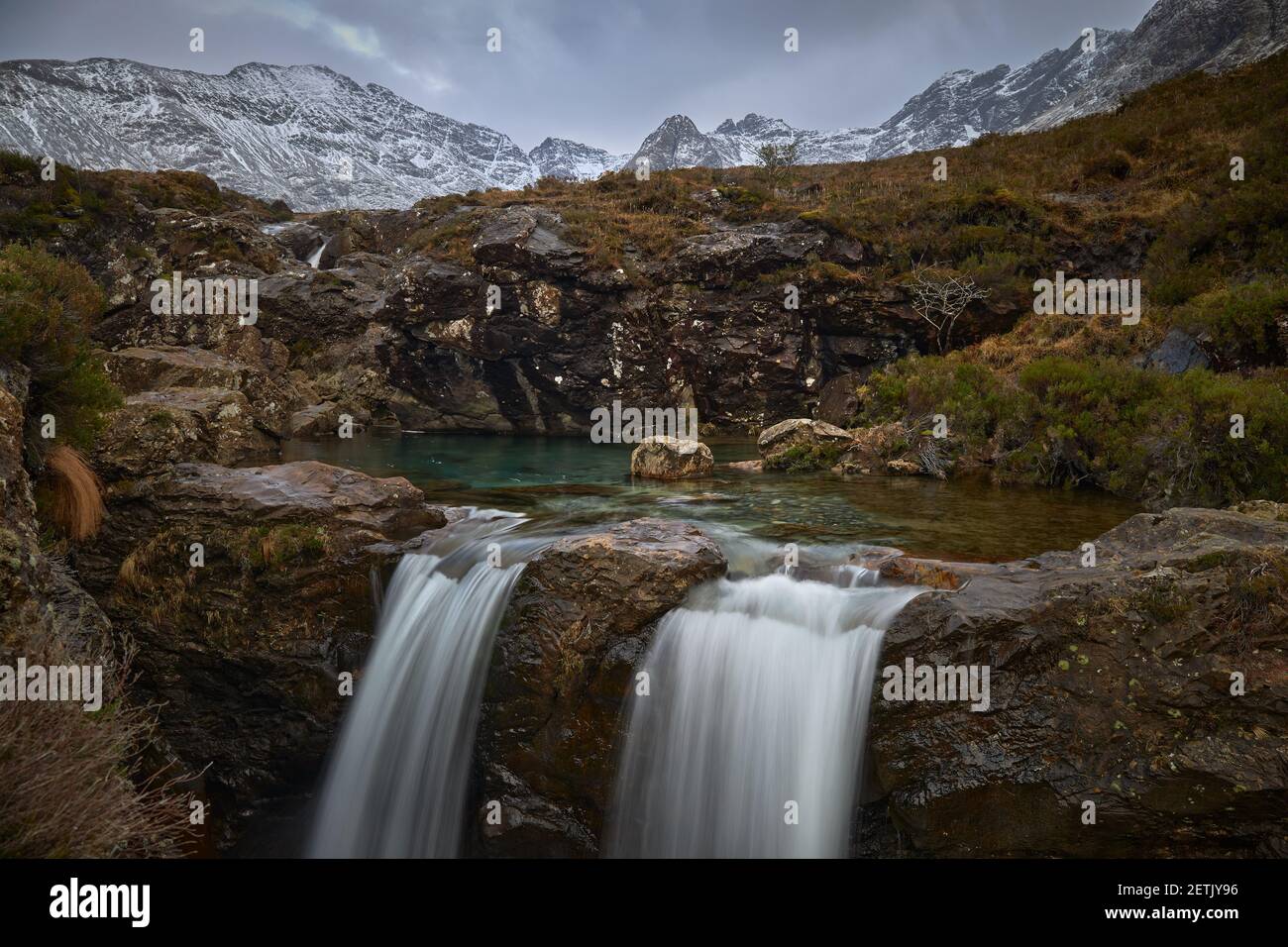 Doppelte Kaskade mit türkisfarbenem Wasser zwischen idyllischer Berglandschaft Mit Schnee - Fairy Pools - Skye Island - Schottland - Vereinigtes Königreich Stockfoto