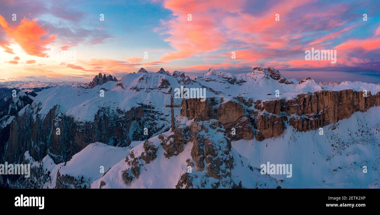 Rosafarbene Wolken bei Sonnenuntergang über Gran Cir Gipfelkreuz und Geislerberge im Winter mit Schnee bedeckt, Dolomiten, Südtirol, Italien Stockfoto