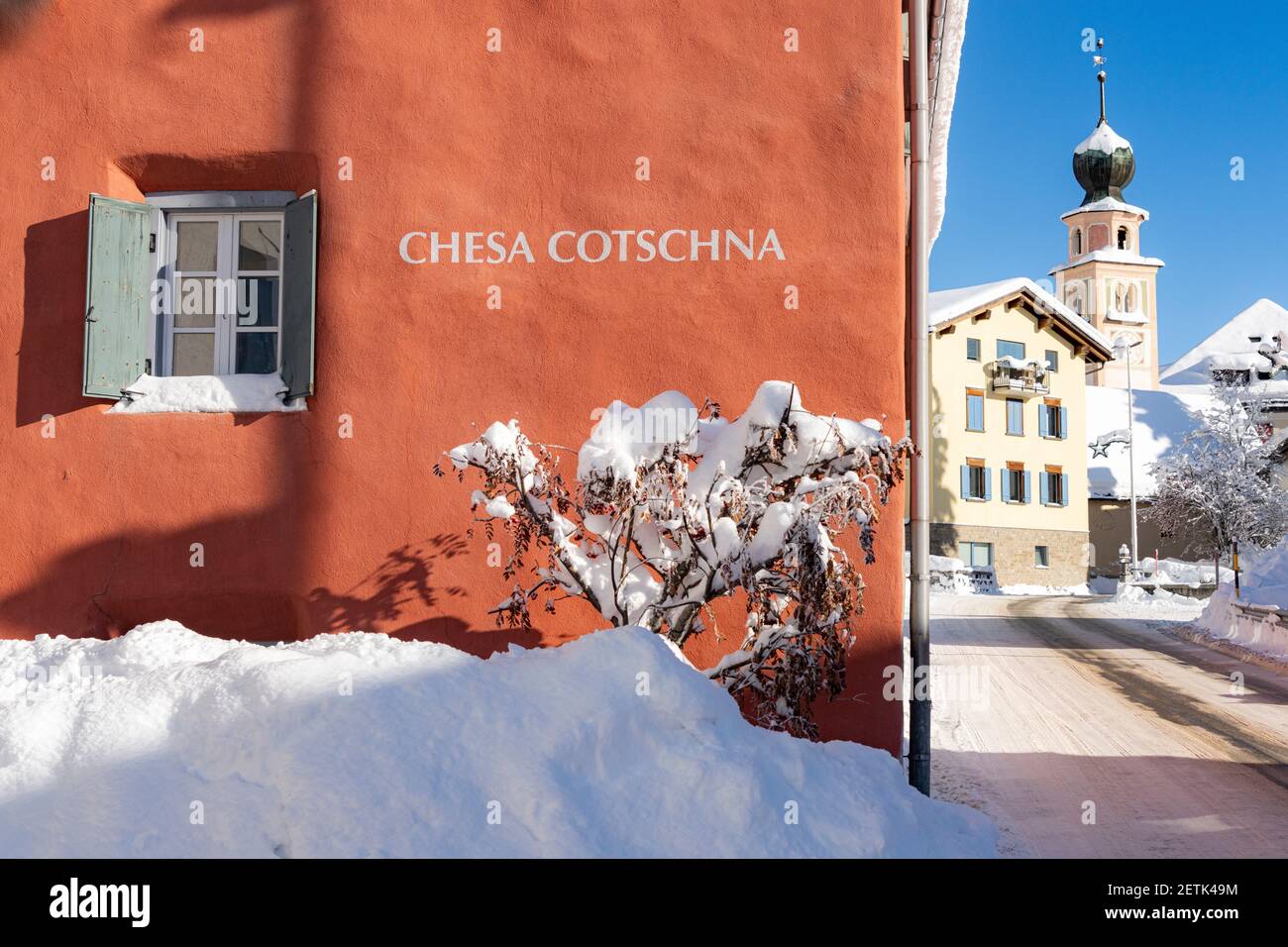 Traditionelles Haus und Kirche in Madulain Dorf im Winter mit Schnee bedeckt, Kanton Graubünden, Engadin, Schweiz Stockfoto