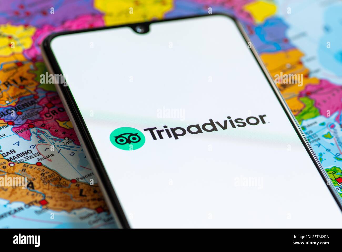 Vilnius, Litauen - März 2 2020: Nahaufnahme der Reisebüro-App Tripadvisor, Symbole, Logo auf einem Smartphone mit einer geografischen Karte auf der Rückseite angezeigt Stockfoto