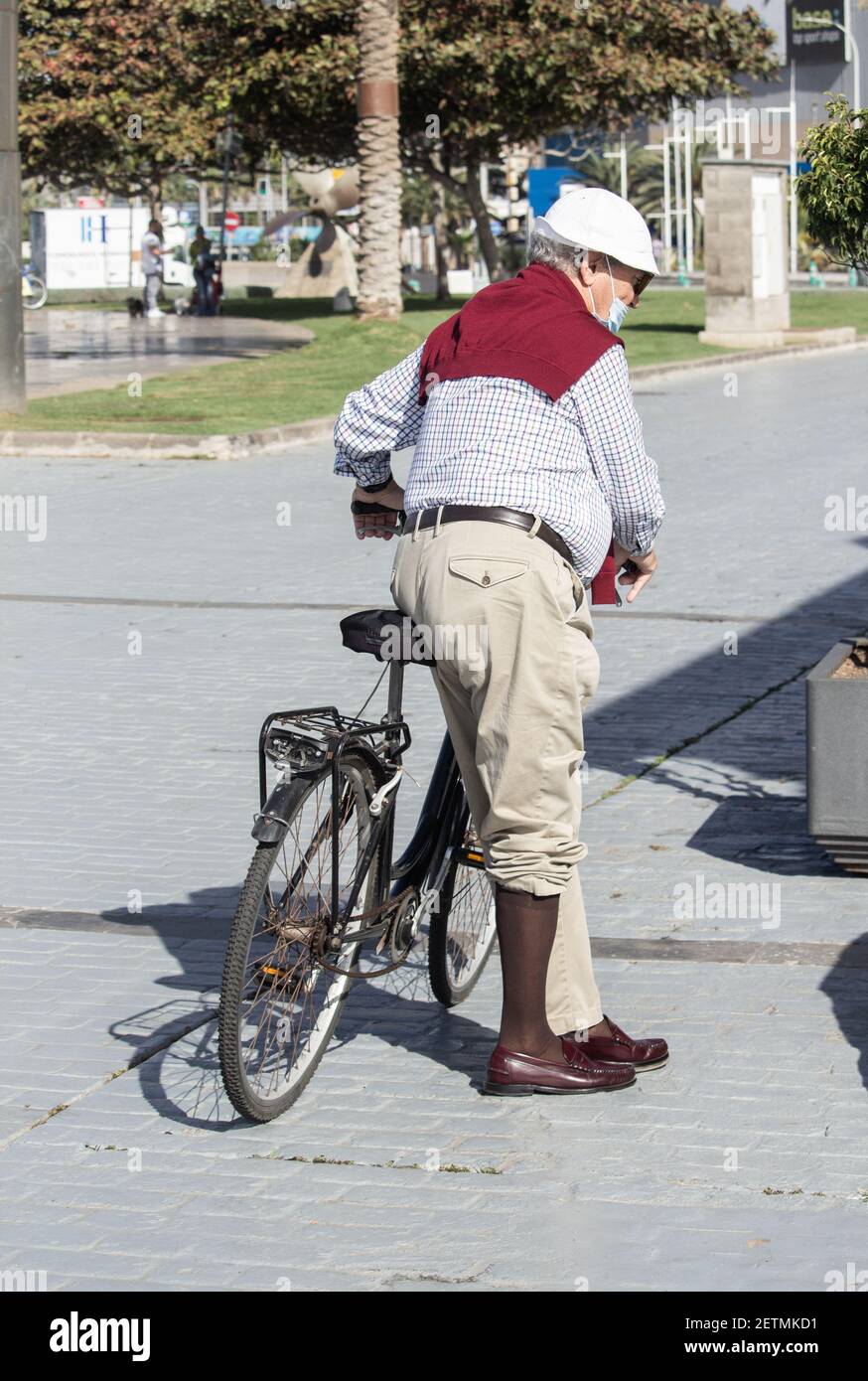 Elegant gekleideter älterer Mann, der Fahrrad fährt. Stockfoto