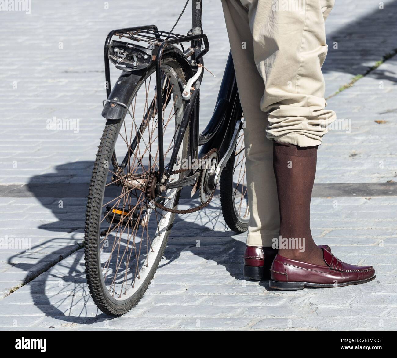 Elegant gekleideter älterer Mann, der Fahrrad fährt. Stockfoto