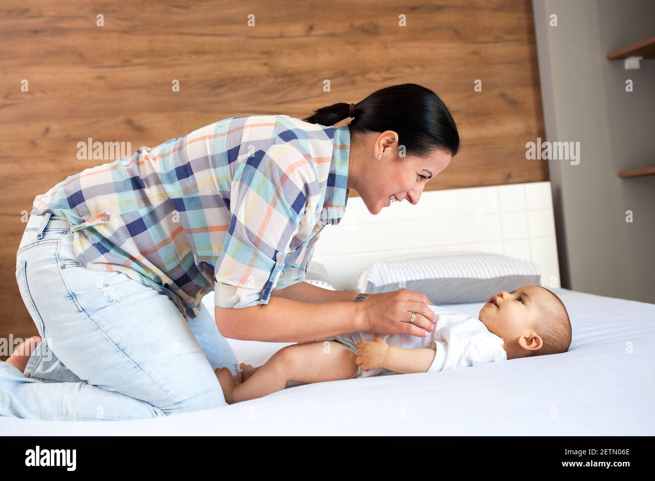 Sanftes Spiel von Mama und ihrem Kind auf der Couch Im Wohnzimmer Stockfoto