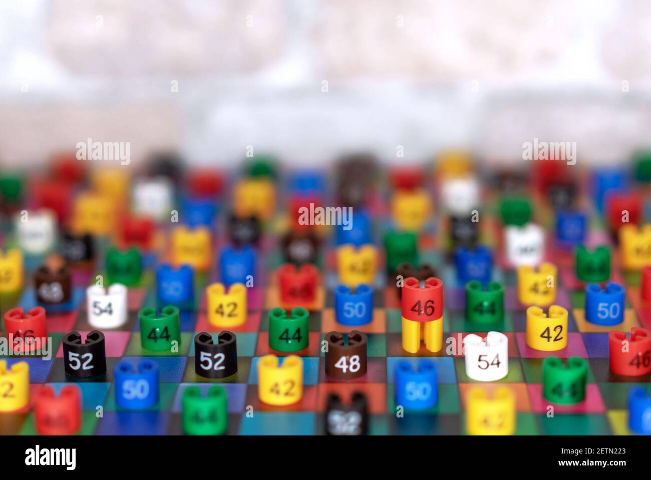Plastikanhänger mit Kleidergrößen auf mehrfarbigen Quadraten. Stockfoto