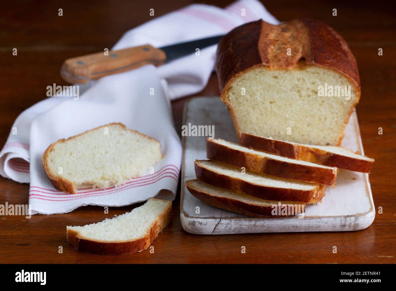 Süßes Brot und Brotscheiben auf einem Holztisch. Stockfoto