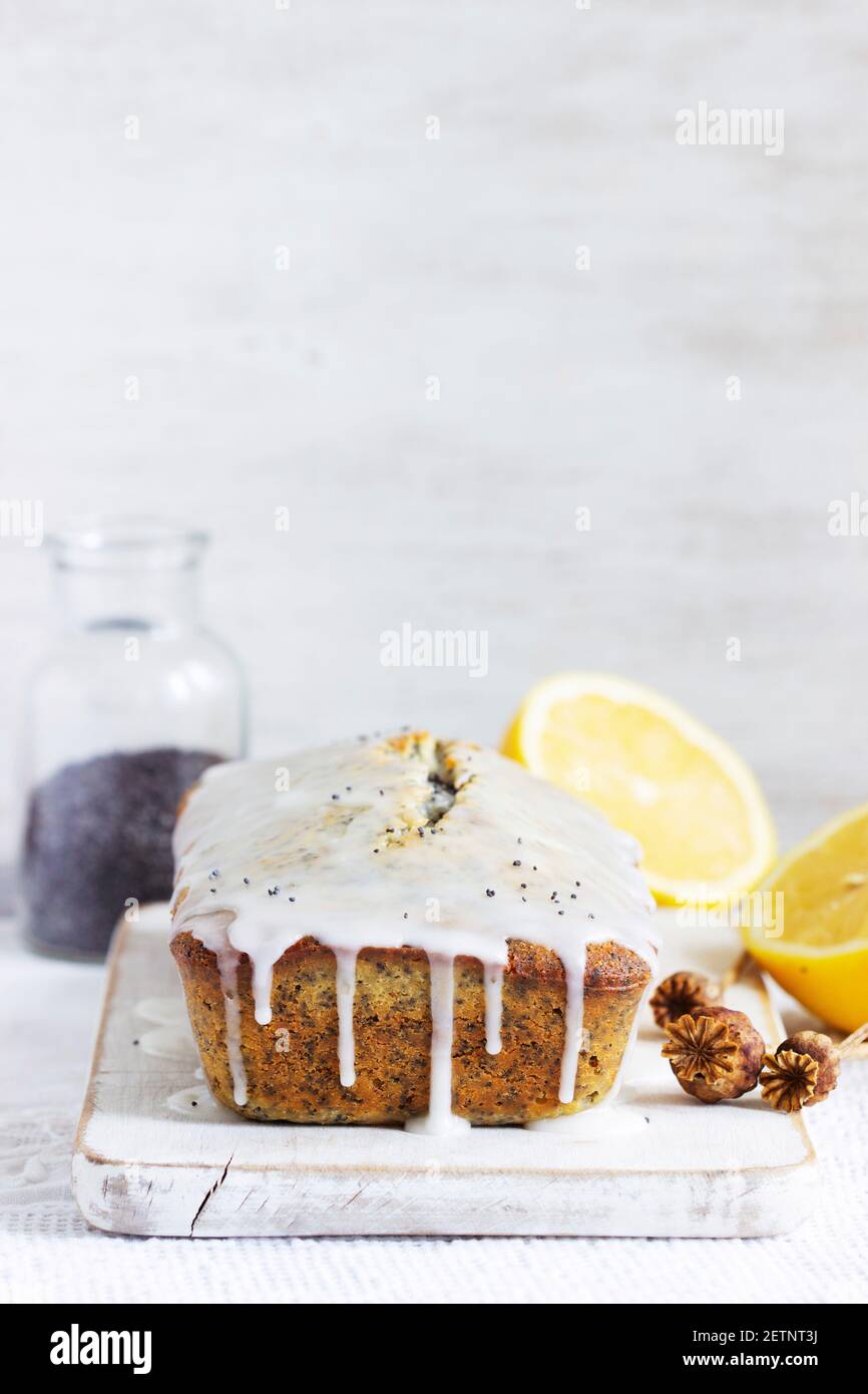 Zitronenkuchen mit Mohnsamen, bedeckt mit Glasur auf hellem Hintergrund. Stockfoto