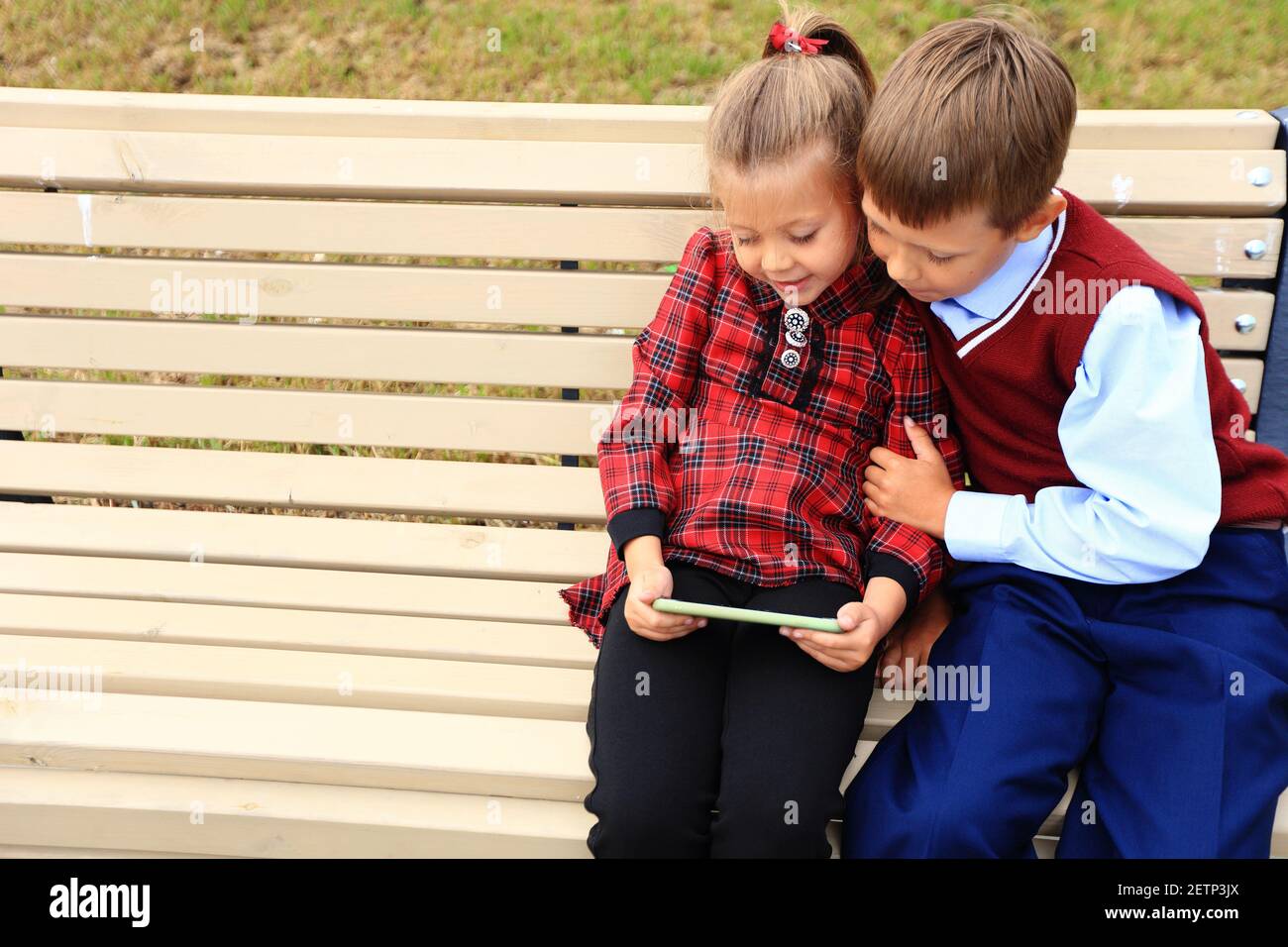 Kinder mit Aktentaschen über den Schultern auf dem Hintergrund der Schule. Stockfoto