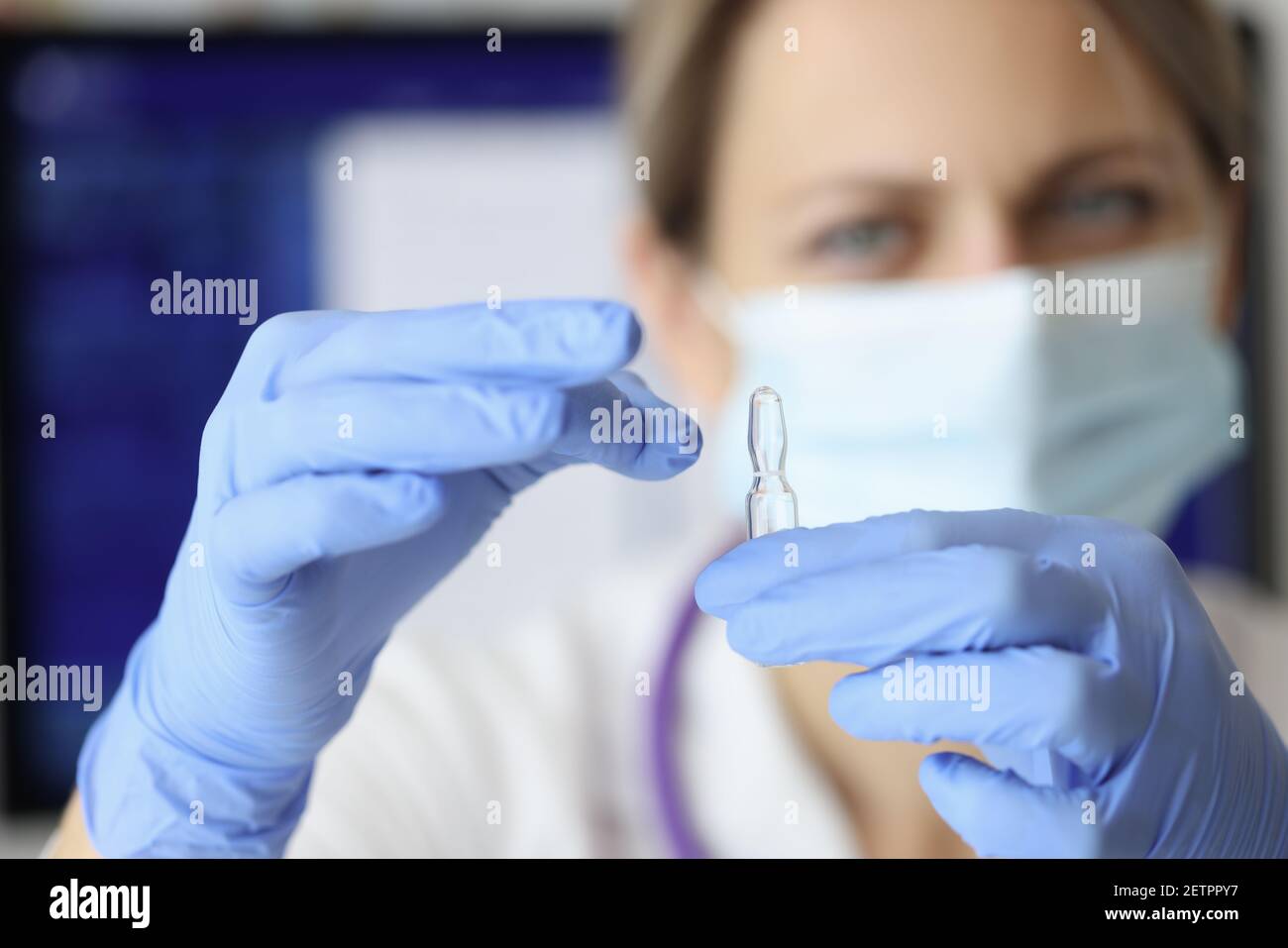 Krankenschwester in Maske und Handschuhe halten Ampulle der Medizin Nahaufnahme Stockfoto