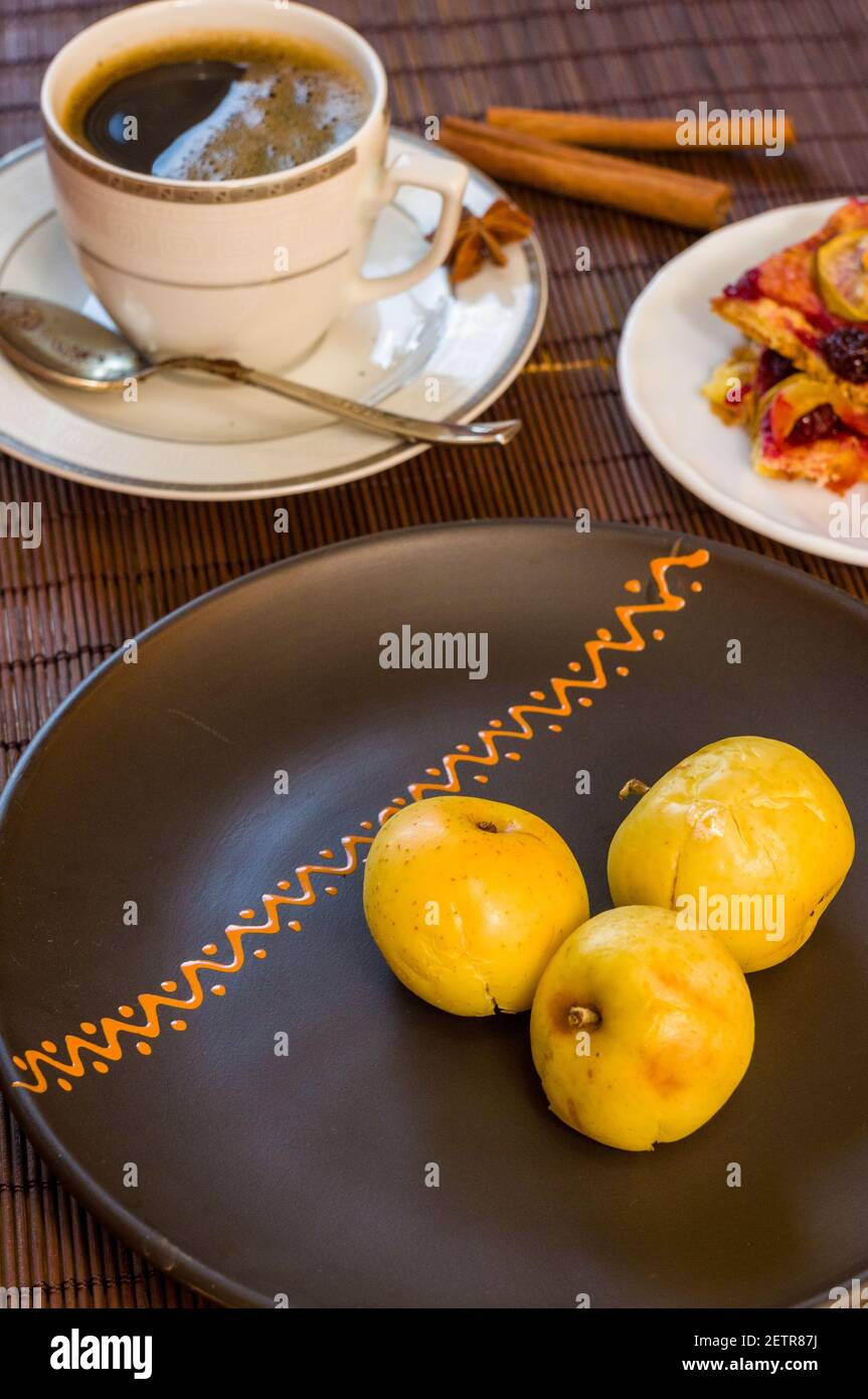 Stillleben - eine Tasse schwarzen Kaffee, hausgemachte Kekse mit Obst, gebackene Äpfel auf einer Bambusmatte Stockfoto