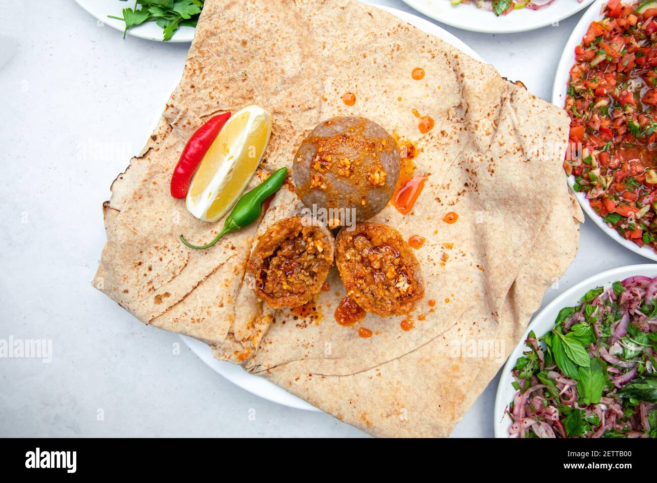 Kibbeh auch bekannt icli kofte - traditionelle arabische Fleischbällchen, Hackfleisch und Bulgur oder Reis Weizen gebraten Snack mit Minze, in weißen Teller auf isoliert w Stockfoto