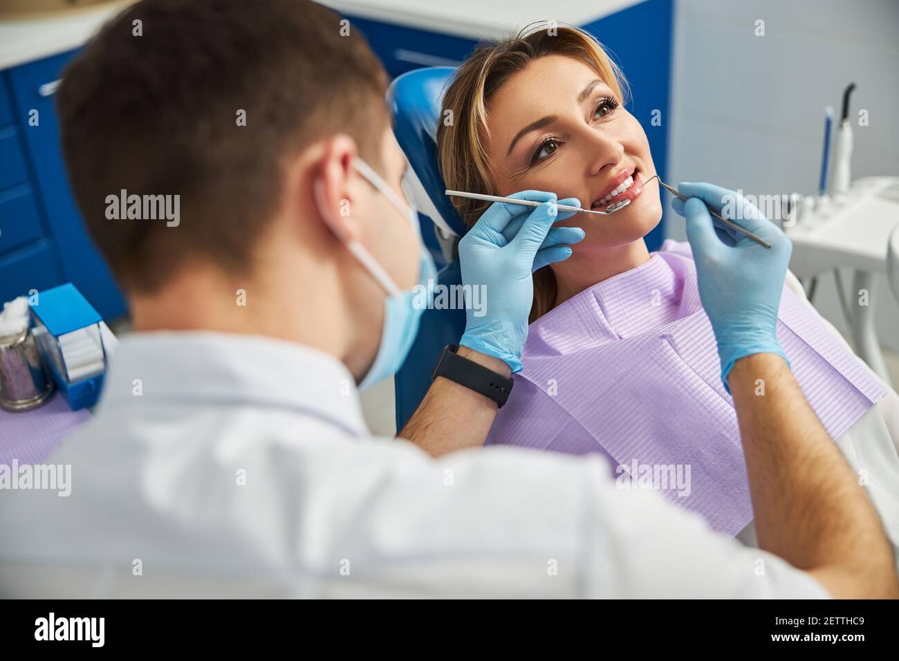 Zahnarzt erreichen mit dental Explorer und Reflektor im Mund des Patienten Stockfoto