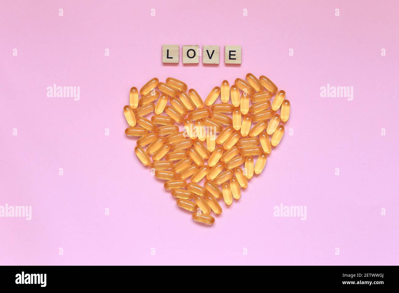 Das Herz aus dem Vitamin liegt auf dem Hintergrund. Pillen in Form des Wortes Liebe sind auf dem Tisch. Hochwertige Fotos Stockfoto